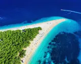 Widok z lotu ptaka na słynne chorwackie plaże Zlatni Rat. Turkusowa woda, biały piasek i zielony las tworzą rajski krajobraz.