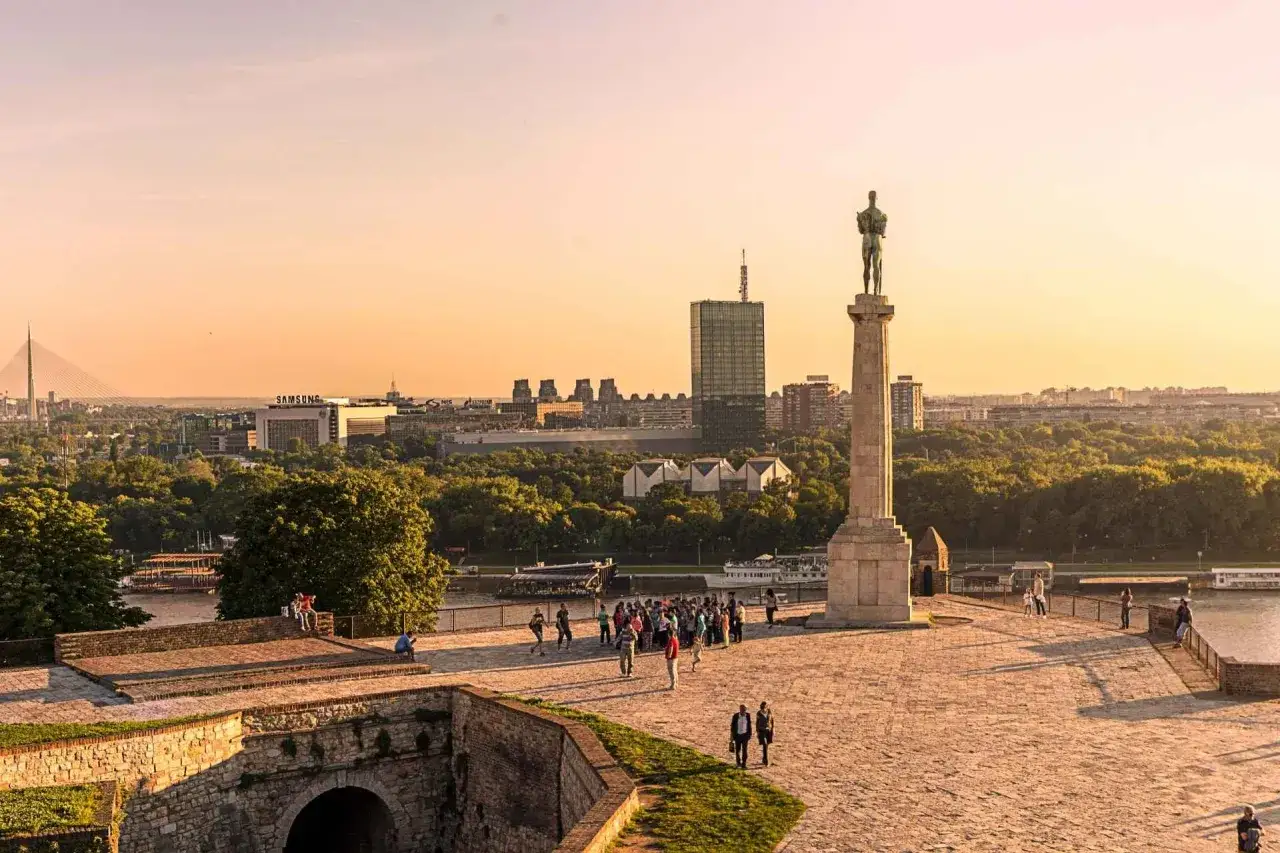 Pomnik Zwycięzcy na twierdzy Kalemegdan to jedno z miejsc, które warto zobaczyć w Belgradzie. Widok na miasto i rzekę o zachodzie słońca.