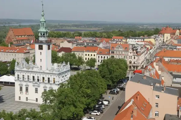 Widok na rynek w Chełmnie z ratuszem i wieżą. W tle kamienice i zieleń, idealne chełmno atrakcje.